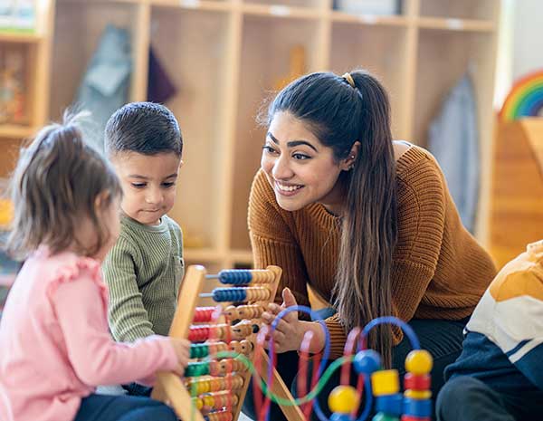 Nevada Early Childhood Advisory Council Home Page Ec Professionals Educator and young children playing with building blocks