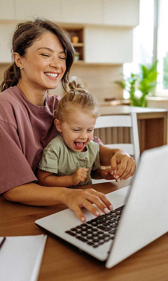 Nevada ECAC About Us Early Childhood Professionals Public Meetings Parent working on a laptop with a young child