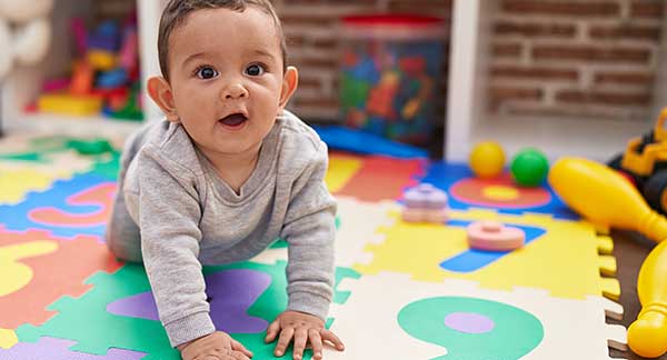 Baby crawling on a colorful foam play mat