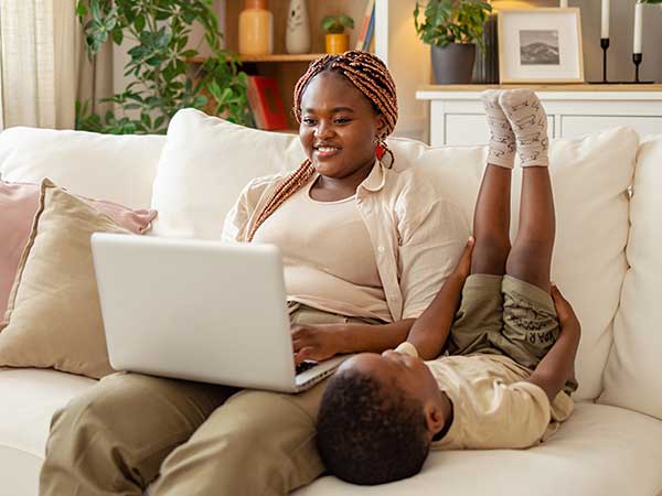 Nevada ECAC General Meetings Becoming Member 2 Parent using a laptop while resting with a child