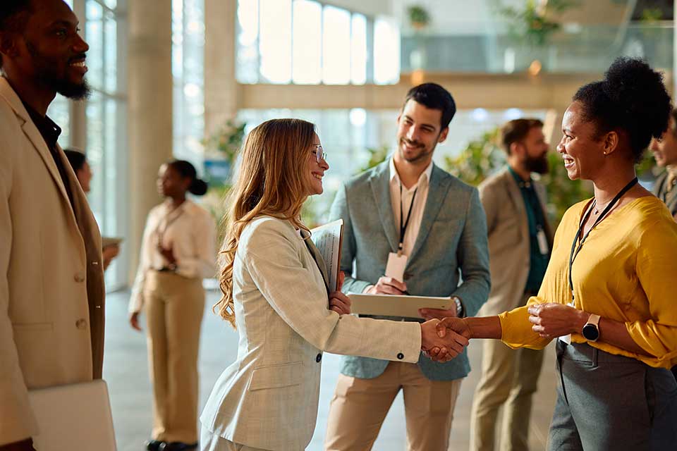 Adults greeting one another with a handshake