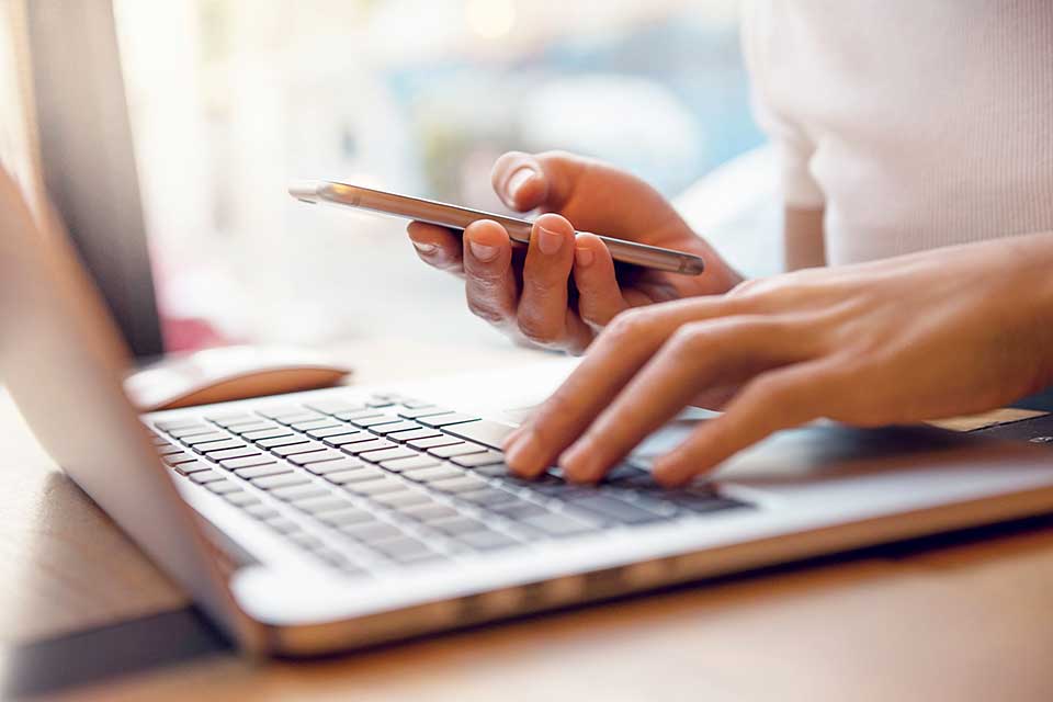 Hands typing on a laptop keyboard