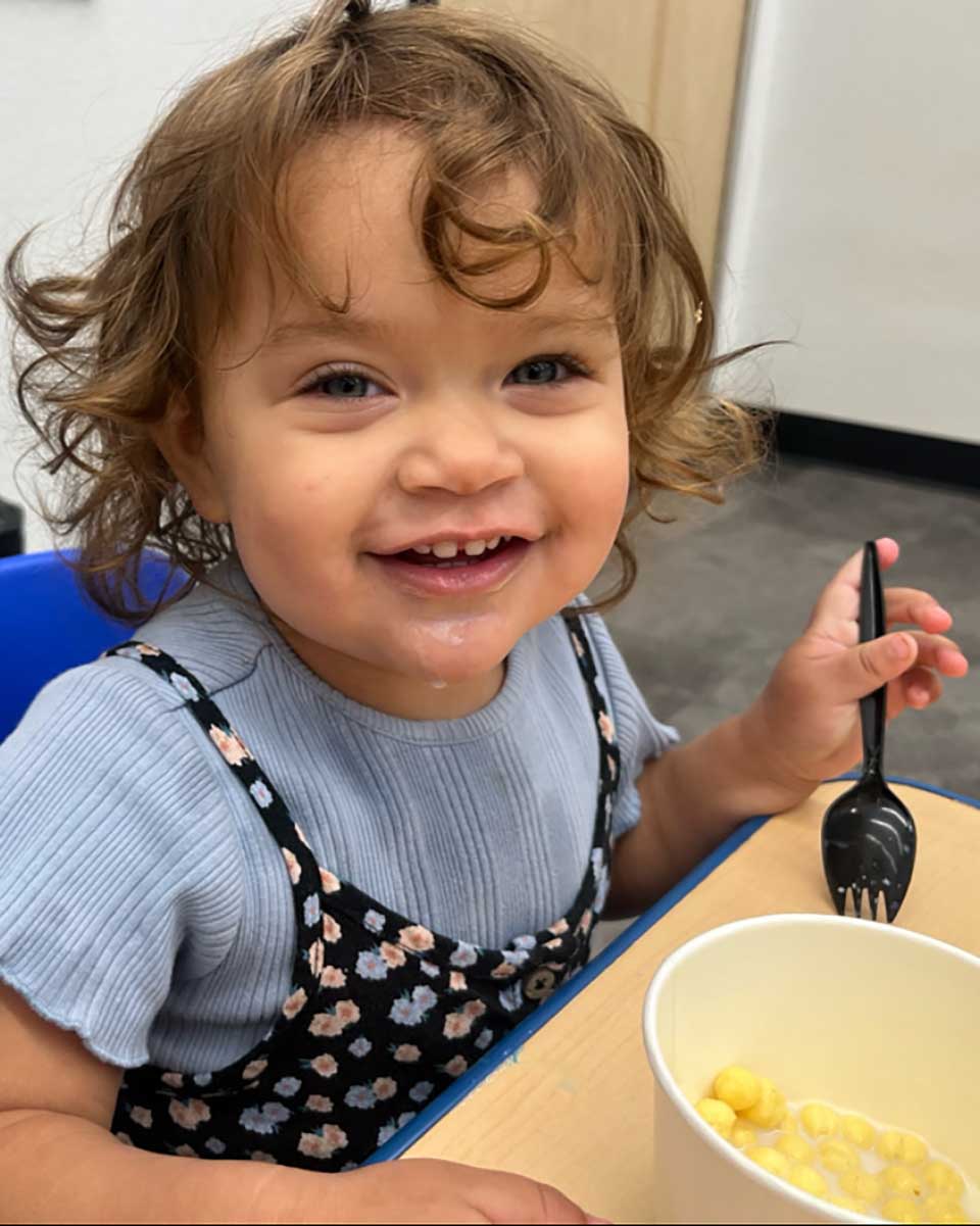 Nevada ECAC Reports and Documents Strategic Plan Planning Smiling toddler eating from a bowl