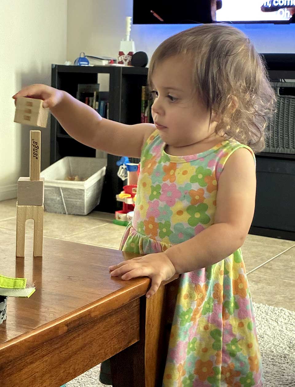 Young girl standing at a table during a hands-on activity