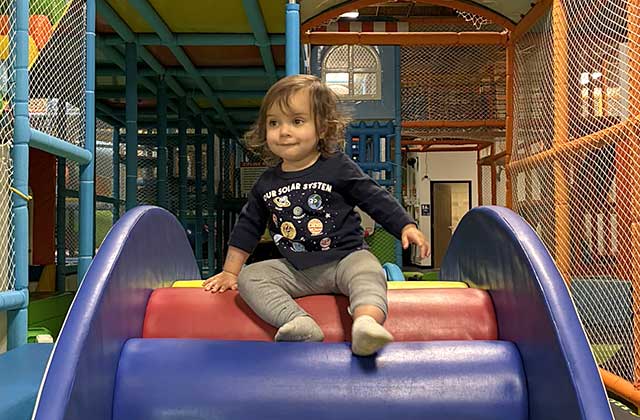 Child playing inside a colorful inflatable play area