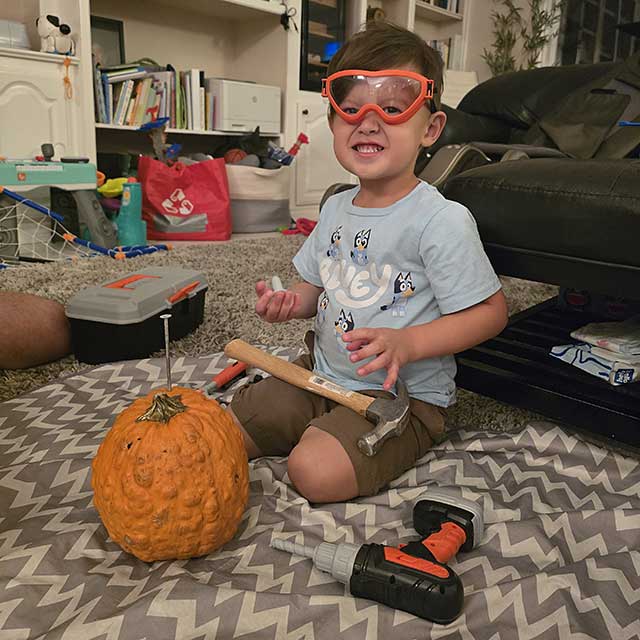 Young child exploring a pumpkin during a sensory activity
