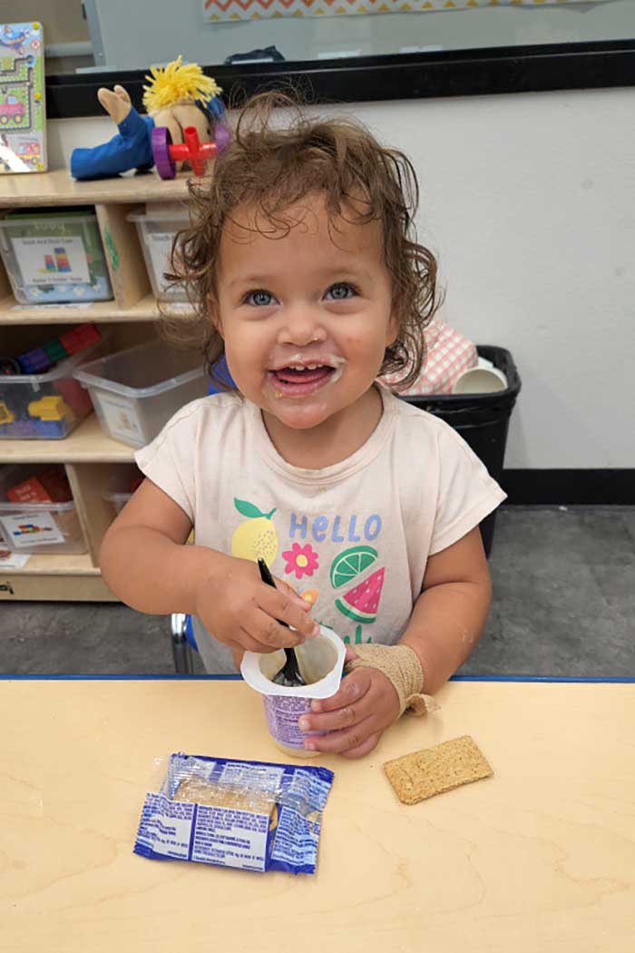 Smiling toddler in a classroom
