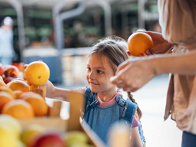Adult helping a young child with toys at a table