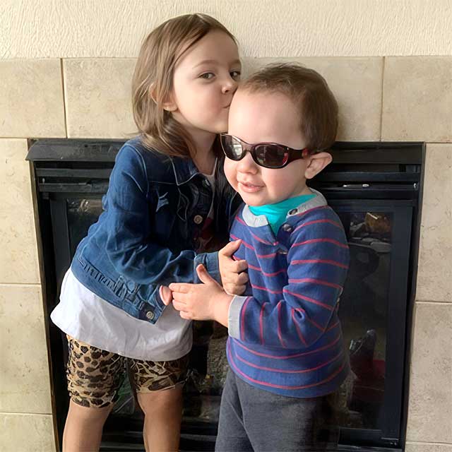 Caregiver helping a child put on sunglasses